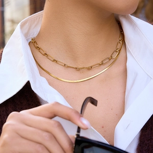 Layered gold stainless steel paperclip and herringbone chain necklaces on a female model