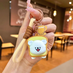 Cute cartoon puppy on toast keychain with a brown braided rope and mini coffee cup charm