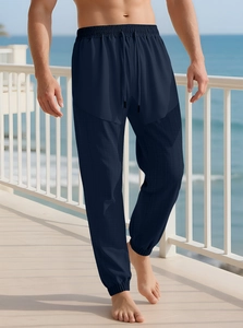 Detail of navy blue drawstring jogger pants with textured waffle knit fabric by the sea