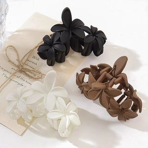 Set of three matte flower hair claws in black, white, and brown with a vintage aesthetic