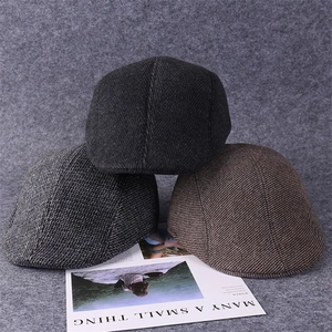 Detailed view of three vintage wool blend flat caps in grey and brown textured twill fabric