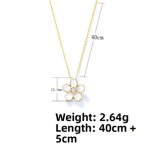 Macro view of gold flower pendant necklace with central cubic zirconia on a white background