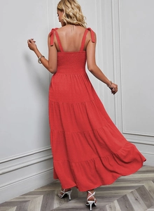 Détail d'une robe longue rouge à pois avec dos nu et fines bretelles à nouer élégantes