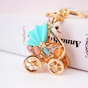 Golden rhinestone baby carriage keychain with swan handle and colorful crystals