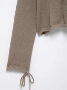 Vue détaillée du haut en maille marron avec motifs ajourés en losange et lien décoratif
