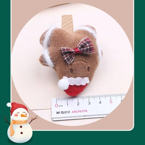 Detail showing plush gingerbread man charm with red-green bow and size ruler measurement