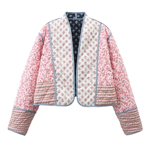 Detail of quilted reversible jacket featuring pink floral patchwork and soft cotton texture
