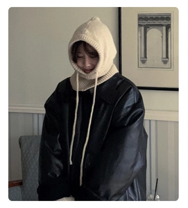 Detail of cream knit balaclava hood showing soft wool texture and long adjustable drawstrings
