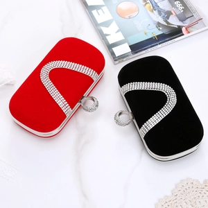 Detailed view of red and black velvet evening clutch bags with U-shaped crystal embellishments