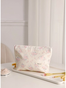 Floral canvas makeup bag in cream with pink flower pattern on white tray and pleated curtain