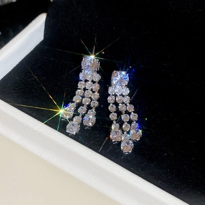 Close-up of sparkling square zircon tassel earrings featuring a shimmering starburst effect