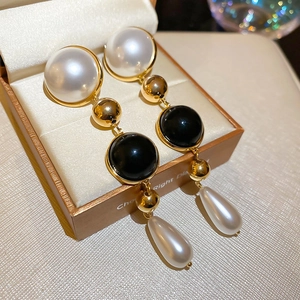 Detail of vintage teardrop pearl earrings with black bead on a luxury jewelry box