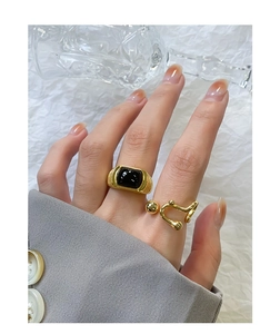 Detailed view of an S925 silver ring with black agate inlay and a gold geometric open band