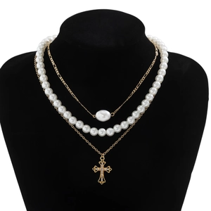 Three-layer layered necklace featuring white pearls and a sparkling cross pendant charm