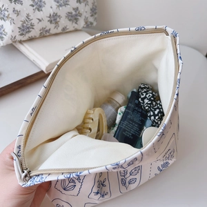 Top view of open floral canvas pouch showing storage capacity for cosmetics and skincare