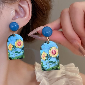 Detail of oil painting sunflower earrings with blue stud and gold metal connectors