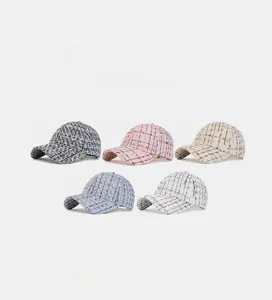 Flat lay of tweed baseball caps in five colors showing woven texture and soft crown detail