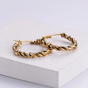 Elegant golden twisted rope hoop earrings with high-gloss metallic finish on a white base