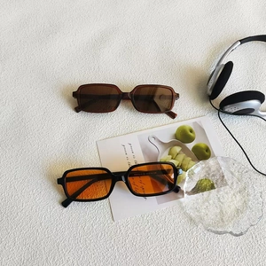 Vintage rectangle sunglasses in brown and black-orange colors on a white textured background
