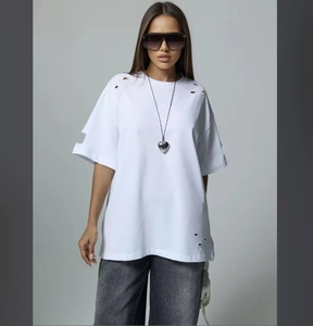 Close-up of vintage distressed white T-shirt with frayed edges and hole details