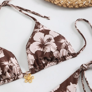 Detail of floral bikini top with tropical print and gold petal pendant embellishment