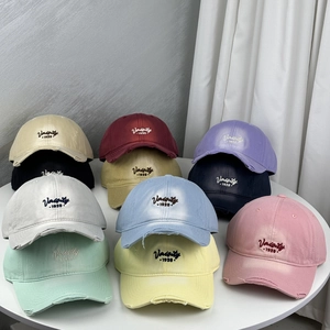 Flat lay of multi-color distressed baseball caps with Varsity 1920 embroidery detail