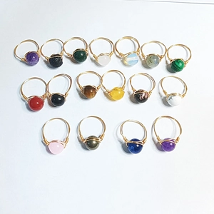Detail showing various handmade wire-wrapped gemstone rings with amethyst and tiger eye stones