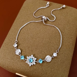 Detail of adjustable silver snowflake bracelet featuring sea blue stones and zircon