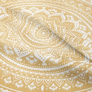 Close-up of mustard yellow mandala tapestry fabric showing intricate white floral patterns