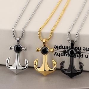 Detailed view of anchor pendants in silver, gold, and black with black gemstones