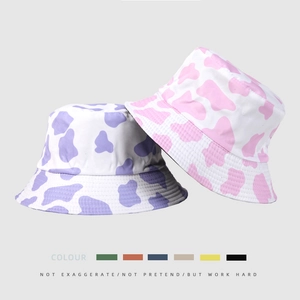 Double-sided cow print bucket hats in purple and pink displayed with color palette