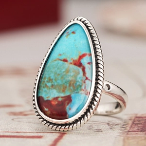 Primer plano de anillo turquesa de lágrima con textura de cuerda plateada de estilo retro