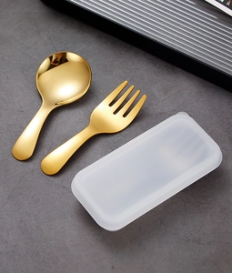 Close-up of golden stainless steel mini spoon and fork set with a compact storage case