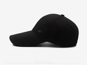 Side view of black baseball cap with extended brim and small metal logo plaque