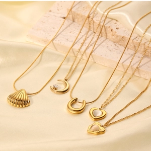 Detail showing assorted gold-plated necklaces with shell and cat eye heart pendants