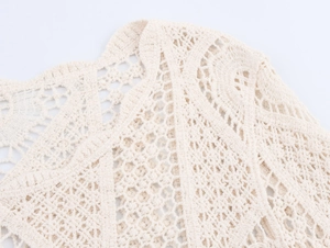 Detailed close-up of beige crochet hollow knit fabric with intricate geometric patterns