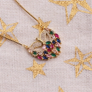 Exquisite gold butterfly necklace with colorful marquise zircons on a starry background