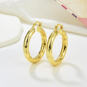 Vintage hollow gold-plated hoop earrings with intricate floral texture and twist design