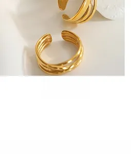 Dettaglio dell'anello dorato multistrato a corda con design aperto regolabile