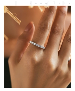 Close-up of eternity ring with round moissanite stones in s925 silver on model finger