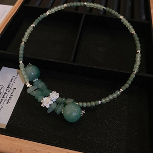 Dettaglio della collana in stile New Chinese con perle di giada verde e fiori di metallo