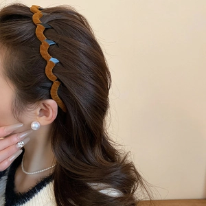 Detailed view of brown velvet wavy headband with anti-slip teeth on a female model
