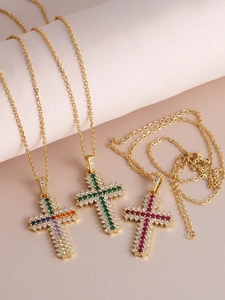 Detailed macro view of three gold cross necklaces with colorful zircons and micro diamonds