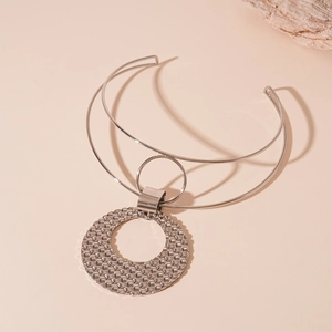 Detail van zilveren dubbellaagse metalen choker met grote ring en ronde hanger met textuur