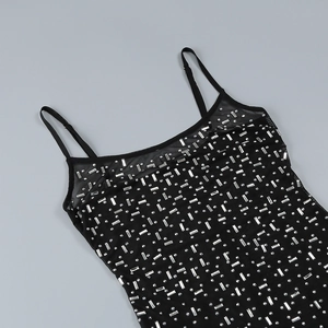 Macro shot of silver rhinestones on black mesh fabric with delicate spaghetti straps