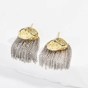 Détail de boucles d'oreilles à pompons bicolores avec blocs dorés et chaînes argentées