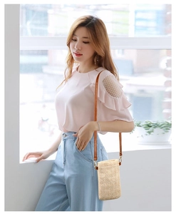 Pink chiffon top with mesh lace shoulder detail paired with a straw crossbody bag