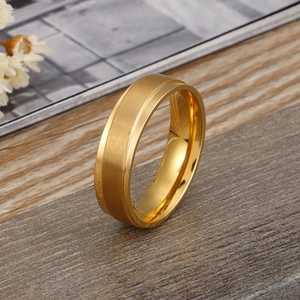 Anello minimalista in acciaio al titanio spazzolato oro su superficie in legno