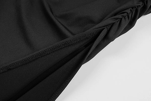 Detailed macro view of side ruching and fine stitching on black bodycon dress fabric