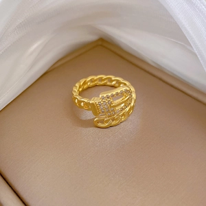 Close-up of golden belt buckle ring with white crystals on silk background